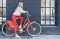 Young pretty sensual blond girl posing outdoor with red vintage bicycle in a red Chinos Trouser in gold sneakers, fashionable styl Royalty Free Stock Photo