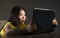 Young pretty shocked and surprised Asian Korean woman looking stressed at laptop computer feeling amazed and scared in cyber bully Royalty Free Stock Photo