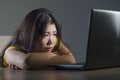 Young pretty shocked and surprised Asian Korean woman looking stressed at laptop computer feeling amazed and scared in cyber bully Royalty Free Stock Photo