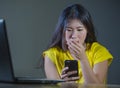Young pretty shocked and surprised Asian Korean woman looking stressed at mobile phone feeling worried and scared in cyber bullyin Royalty Free Stock Photo