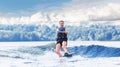 Young pretty slim brunette woman riding wakeboard on wave of motorboat in summer lake Royalty Free Stock Photo