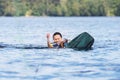 Young pretty slim brunette woman riding wakeboard on wave of motorboat in summer lake Royalty Free Stock Photo