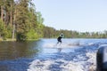 Young pretty slim brunette woman in wetsuit riding wakeboard on Royalty Free Stock Photo