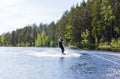 Young pretty slim brunette woman in wetsuit riding wakeboard on Royalty Free Stock Photo