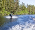 Young pretty slim brunette woman in wetsuit riding wakeboard on Royalty Free Stock Photo