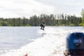 Young pretty slim brunette woman in wetsuit riding wakeboard on Royalty Free Stock Photo