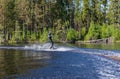 Young pretty slim brunette woman in wetsuit riding wakeboard on Royalty Free Stock Photo