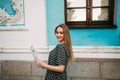 Girl with a paper guide in her hands, stands near the facade of an ancient museum Royalty Free Stock Photo