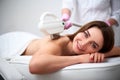 Young pretty smiling woman back laser epilation in beauty salon. Cosmetologist doing depilation treatment with elos Royalty Free Stock Photo