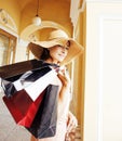 Young pretty smiling woman in hat with bags on shopping at store Royalty Free Stock Photo