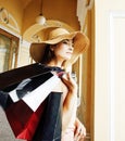 Young pretty smiling woman in hat with bags on shopping at store Royalty Free Stock Photo