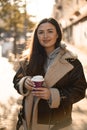 Young pretty smiling woman is holding a disposable cup with coffee Royalty Free Stock Photo