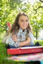 Young pretty student lying on the grass smiling at camera Royalty Free Stock Photo