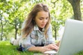 Young pretty student lying on the grass using laptop Royalty Free Stock Photo