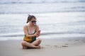 Young pretty and sweet Chinese Asian woman sitting on the beach using mobile phone sending text and chatting happy Royalty Free Stock Photo