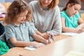 Pretty teacher solves homework together with the student