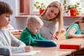 Pretty teacher solves homework together with the student