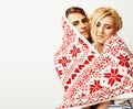 Young pretty teenage couple at Christmas time warming in red dec Royalty Free Stock Photo