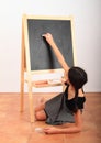 Girl drawing or writing on black blackboard Royalty Free Stock Photo