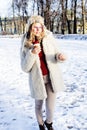 Young pretty teenage hipster girl outdoor in winter snow park having fun drinking coffee, warming up happy smiling Royalty Free Stock Photo