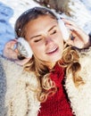 Young pretty teenage hipster girl outdoor in winter snow park having fun drinking coffee, warming up happy smiling Royalty Free Stock Photo