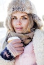 Young pretty teenage hipster girl outdoor in winter snow park having fun drinking coffee, warming up happy smiling Royalty Free Stock Photo