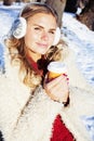 Young pretty teenage hipster girl outdoor in winter snow park having fun drinking coffee, warming up happy smiling Royalty Free Stock Photo