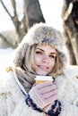 Young pretty teenage hipster girl outdoor in winter snow park having fun drinking coffee, warming up happy smiling Royalty Free Stock Photo