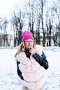 Young pretty teenage hipster girl outdoor in winter snow park having fun drinking coffee, warming up happy smiling Royalty Free Stock Photo