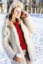 Young pretty teenage hipster girl outdoor in winter snow park having fun drinking coffee, warming up happy smiling Royalty Free Stock Photo