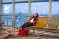 Young pretty tired and exhausted Asian Korean tourist woman in airport sleeping bored sitting at boarding gate hall waiting for de Royalty Free Stock Photo