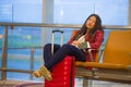 Young pretty tired and exhausted Asian Korean tourist woman in airport sleeping bored sitting at boarding gate hall waiting for de Royalty Free Stock Photo