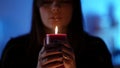 young pretty witch is telling fortune by flame of candle, closeup portrait in darkness Royalty Free Stock Photo