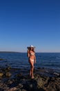 Young pretty woman on the beach sea looking on the islands of Greece