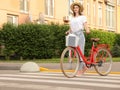 Young pretty woman with bicycle crossing road Royalty Free Stock Photo