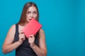 Young pretty woman bites a red book holding in her hands, Royalty Free Stock Photo