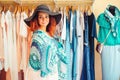 Young pretty woman in black hat trying on new accessories in clothing store. Woman smile and looking to the camera. Shopping Royalty Free Stock Photo