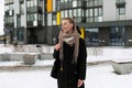 A young pretty woman with blond dreadlocks dressed warmly walks along the street in winter Royalty Free Stock Photo