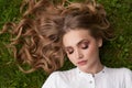 Young pretty woman with blonde hair lying on green grass Royalty Free Stock Photo