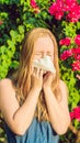 Young pretty woman blowing nose in front of blooming tree. Spring allergy concept VERTICAL FORMAT for Instagram mobile Royalty Free Stock Photo