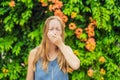 Young pretty woman blowing nose in front of blooming tree. Spring allergy concept Royalty Free Stock Photo