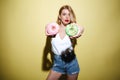 Young pretty woman with bright lips makeup holding donuts. Royalty Free Stock Photo