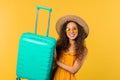 Young pretty woman with carry-on suitcase yellow background. Teenager traveling Royalty Free Stock Photo