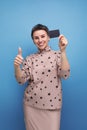 a young pretty woman with childish features with a short haircut dressed in a beige suit recommends a bank card Royalty Free Stock Photo