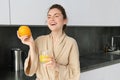 young pretty woman cooking at home, morning kitchen, healthy food, drinking orange juice Royalty Free Stock Photo