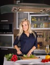 Young pretty young woman cooking salad in kitchen Royalty Free Stock Photo