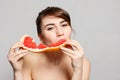 Young pretty woman or cute girl with long hair holds grapefruit fruit slice Royalty Free Stock Photo