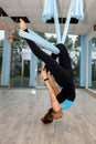 Young pretty woman doing fly yoga stretching exercises in fitness studio Royalty Free Stock Photo