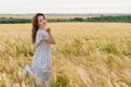 Young pretty woman in dress poses on wheat field Royalty Free Stock Photo