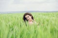 Young pretty woman in dress poses on summer wheat field. Smiling girl on green meadow. Freedom Royalty Free Stock Photo